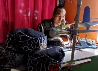 Muhadi saat menjahit peci blangkon